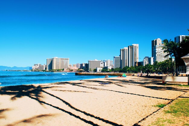 Photo sea and buildings against clear blue sky