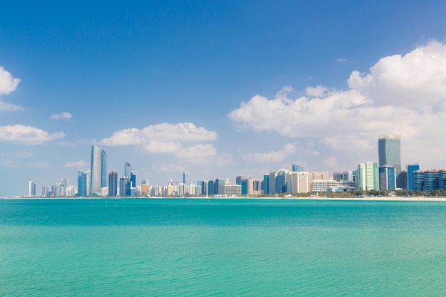 Sea by buildings against blue sky