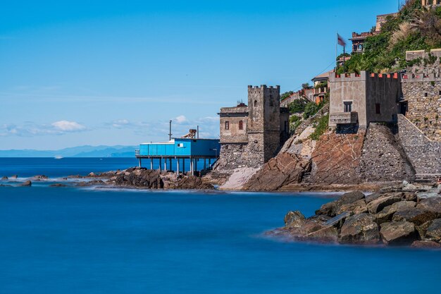 Sea by buildings against blue sky