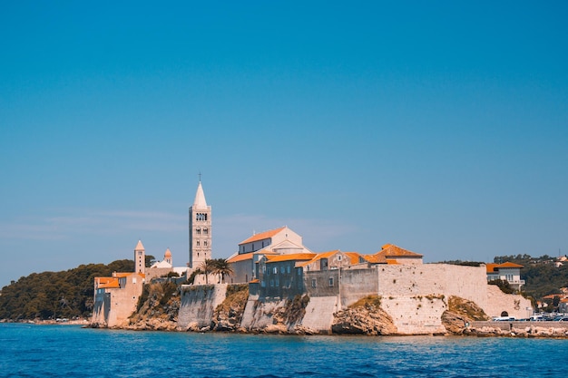 Sea by buildings against blue sky