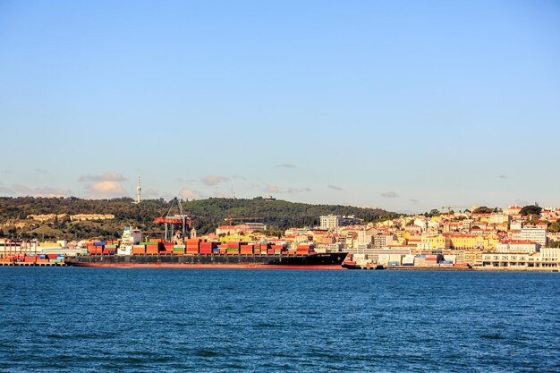 Sea by buildings against clear blue sky