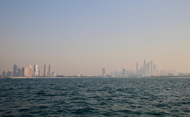 Sea by buildings against clear sky