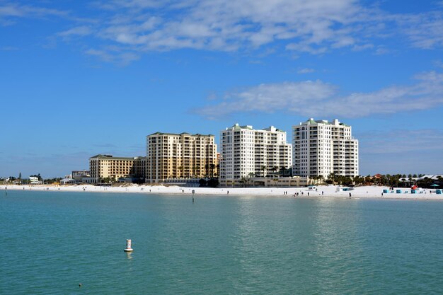 Sea by buildings against sky