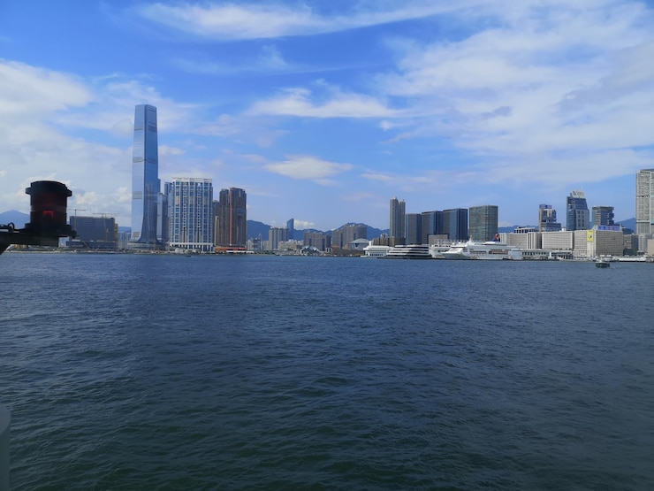 Photo sea by buildings in city against sky