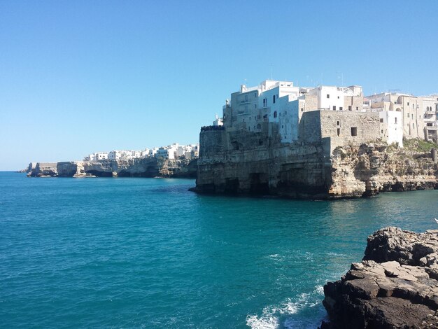 Sea by city against clear blue sky