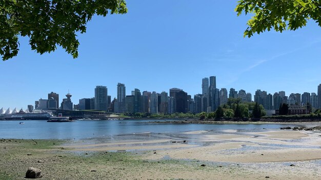 Sea by city buildings against sky