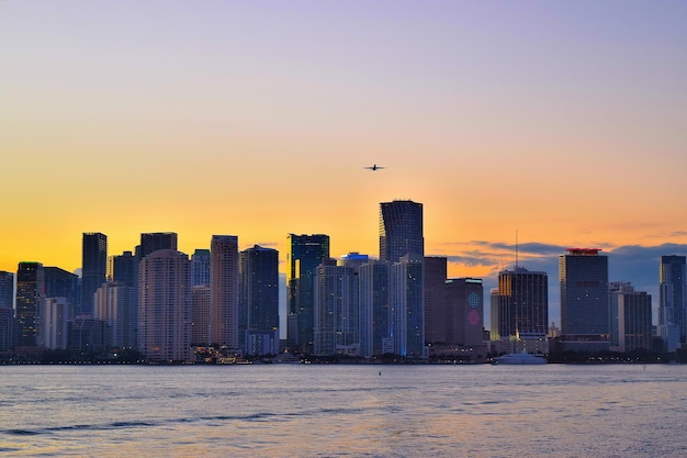 sea by city skyline against sky during sunset