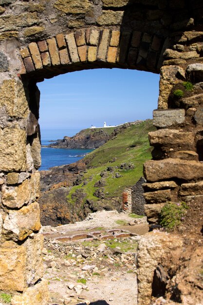 Sea by cliff seen through window