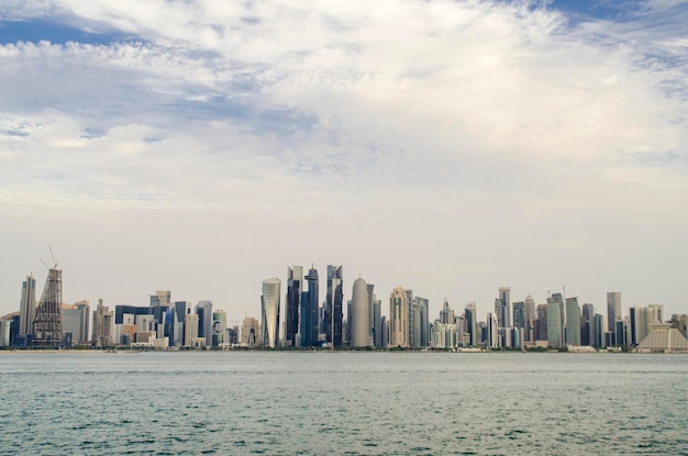 Photo sea by modern buildings against sky in city