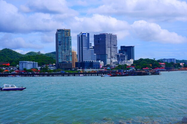 Photo sea by modern buildings against sky in city