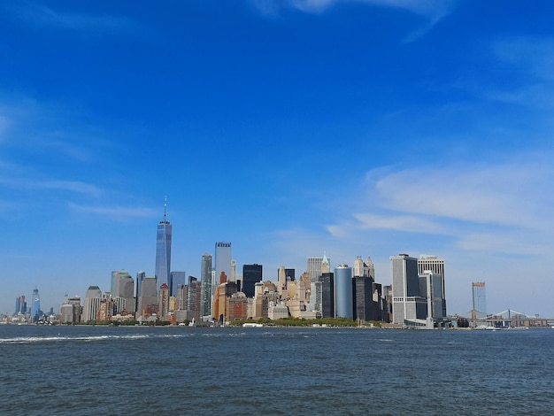 Sea by modern buildings in city against sky