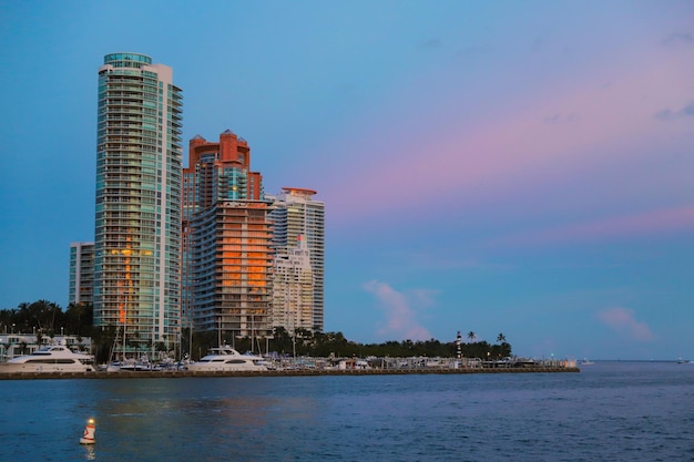 Sea by modern buildings in city against sky