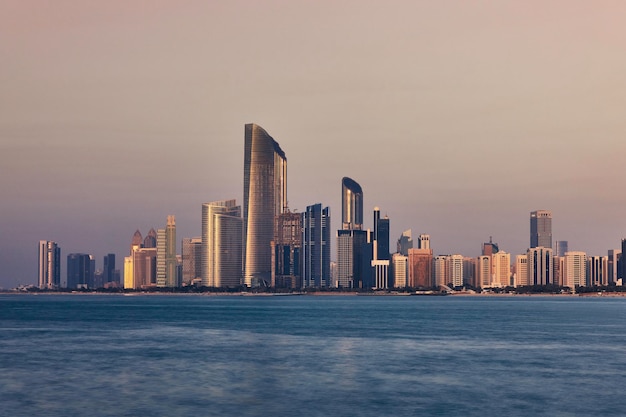 Sea by modern buildings in city against sky