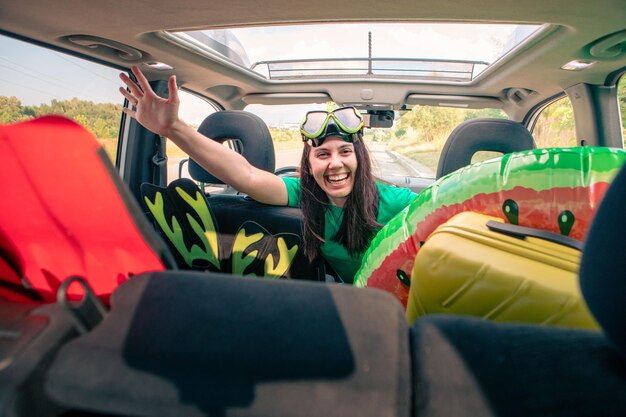 Viaggio in auto per mare donna sorridente autista in auto piena di spazio per la copia di cose per le vacanze