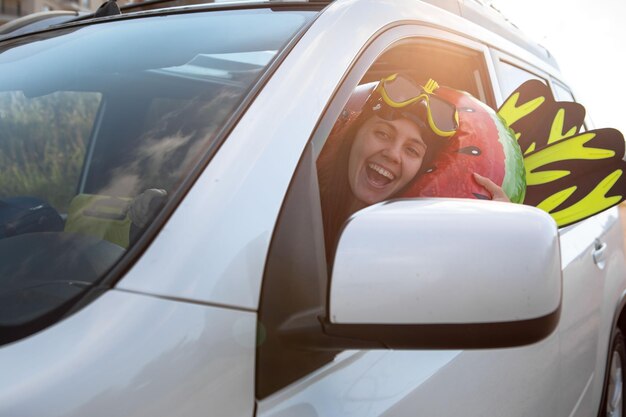 Sea car travel trip smiling woman driver in car full of\
vacation stuff