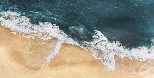 明るい砂と青い海、パノラマのある海岸。海の波、パノラマの景色と砂浜。波のある孤独な砂浜。鳥瞰図から見た海岸。高さからの海岸線。コピースペース