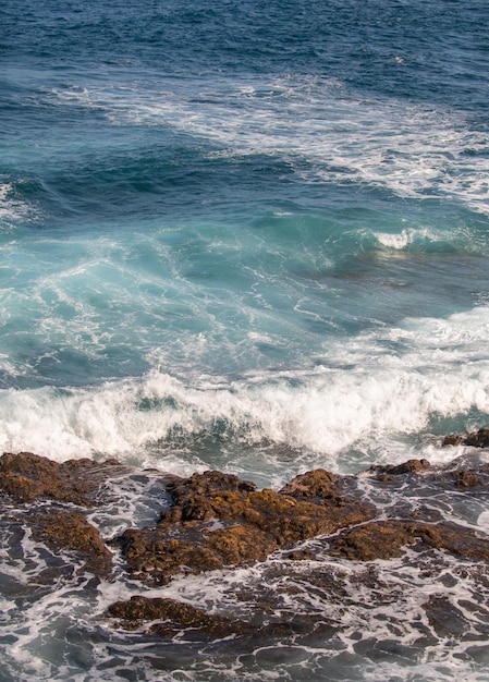 Sea collides with the stones and sand of a beach sea waves lash line impact rock