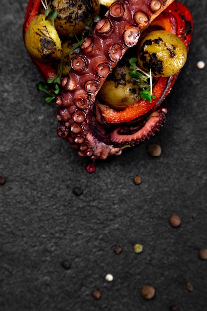 Sea delicacy grilled octopus Dish on a dark background