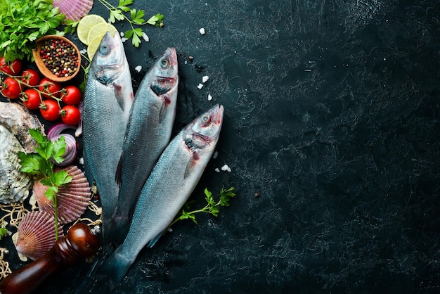 Sea fish seabass Seafood on a black stone background Top view Free copy space