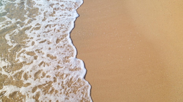 Sea foam on the sand beach top view