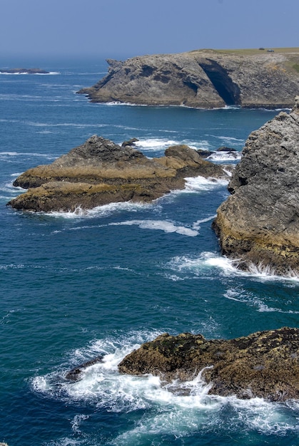 Море голубое волны разбиваются о скалы и измученные скалы на побережье Бель Иль