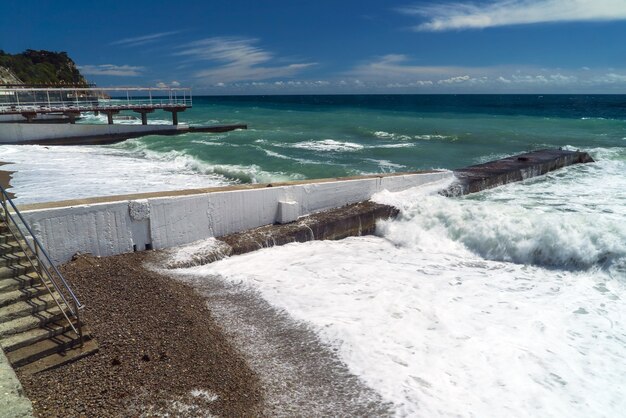 海は荒れています。大きな波が防波堤で砕けます。クリミア。