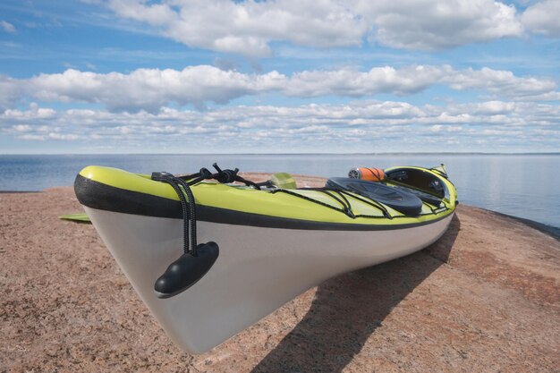 Sea kayak on the granite shore bay in background