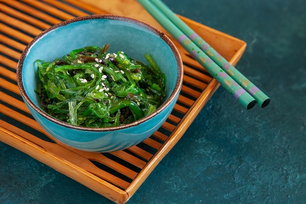 Sea kelp in the bowl on bamboo tray with chopsticks