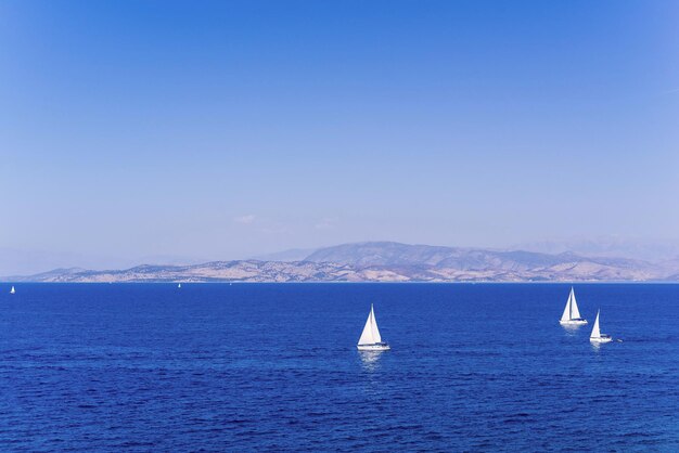 Sea landscape with yachts and a massif on the horizon for a panoramic natural background