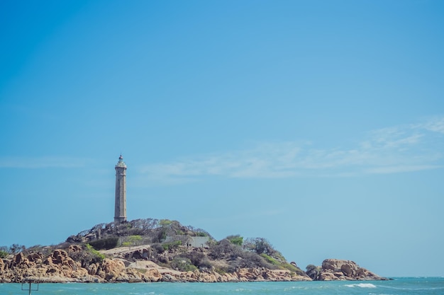 Sea nature panoramic view landscape background ocean rocky
cliffs forested island clear blue sky lighthouse on mountain top
signal warn sailors shipwreck travel concept hope purpose of
life