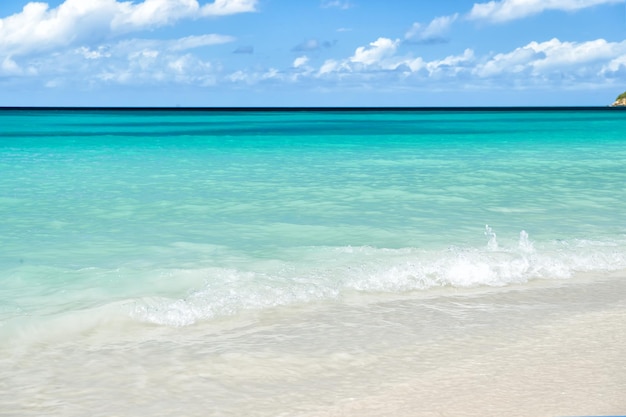 写真 白い砂浜、セントジョンズ、アンティグアのターコイズブルーの水の波と海または海のビーチ。曇り青空を背景に晴れた日の海景。夏、休暇、自然、美しさ、楽園、自由の概念。