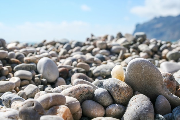 Sea pebbles against the blurred mountain and sky