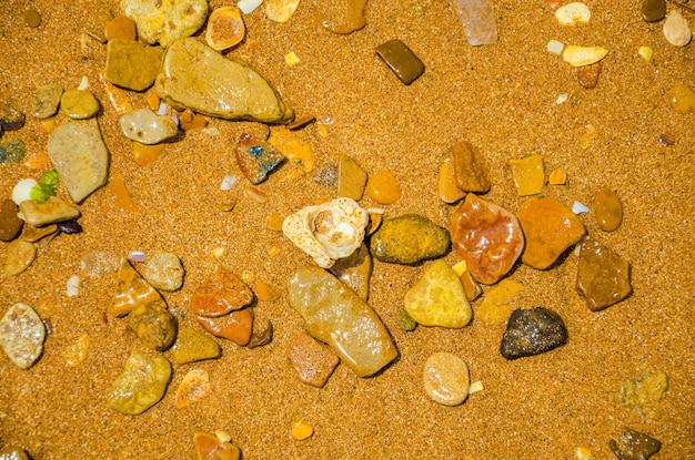 Sea pebbles on the sand on the seashore.