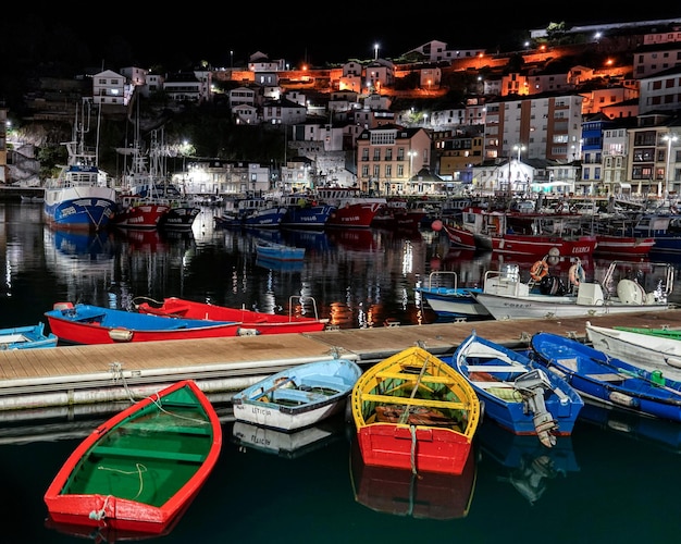 Sea pier at night with colorful boats in Spain