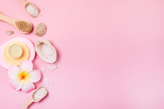 Foto candele aromatiche al sale marino spugne per il viso e spazzola per il viso in bambù fiore di plumeria e misurini di bambù piccoli