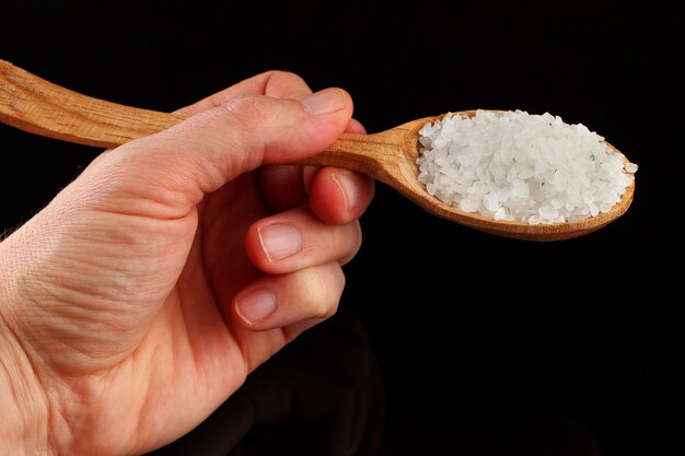 Sea salt in a hand in a spoon