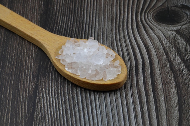 Photo sea salt in a spoon isolated on black background