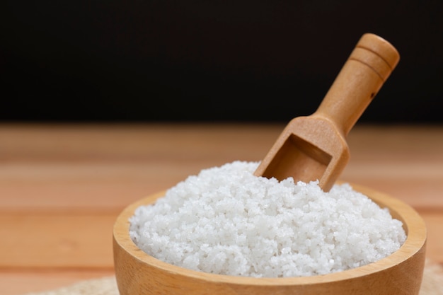 Sea salt on wooden plate on wood table.