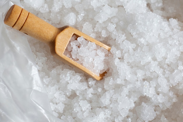 Sea salt on wooden scoop spoon.