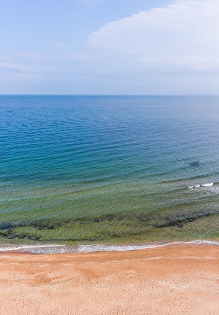 Foto spiaggia di sabbia di mare in tempo soleggiato.