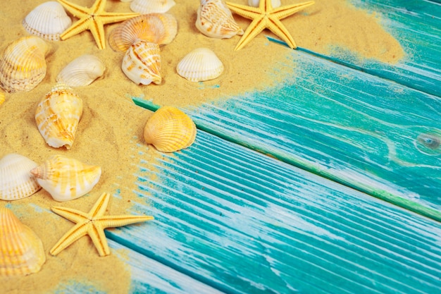 Sea sand and Sea shells on blue wooden floor