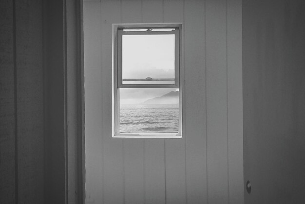 Photo sea seen from open window of house