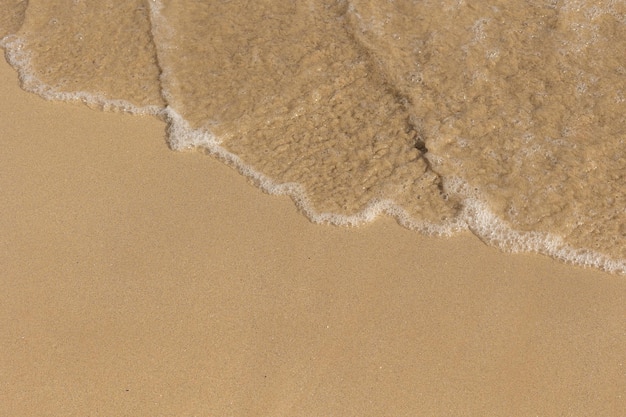 Foto la sabbia e l'acqua della riva del mare viste dall'alto