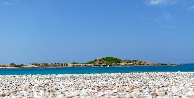 The sea shore with stones and the blue sky