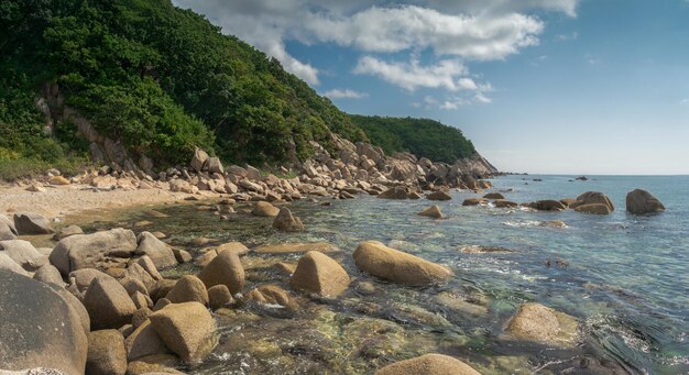 Photo sea shore with transparent water and stones at the bottom