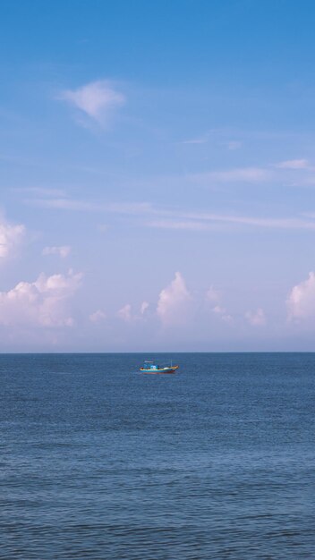 Sea sky cumulus cloud landscape view background Calm water alone fishing boat Destination aim progress concept