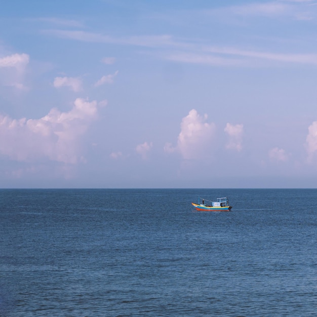 Sea sky cumulus cloud landscape view background Calm water alone fishing boat Destination aim progress concept