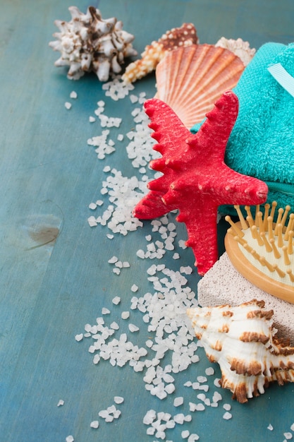 Sea spa treatment with red starfish on blue wooden background