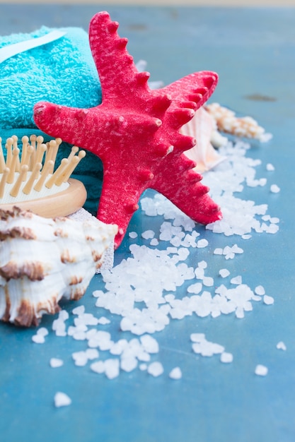 Sea spa treatment with red starfish on blue wooden table