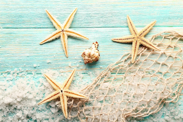 Sea stars on sea salt on wooden background